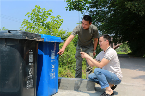 村干部正在指导村民扫二维码学习垃圾分类知识.jpg