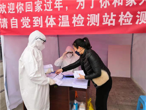 图为唐红霞赴监测点发放防控知识手册.jpg