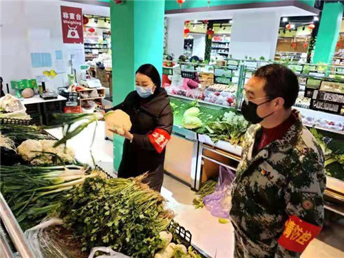 网格员正在帮助隔离群众采购蔬菜.jpg