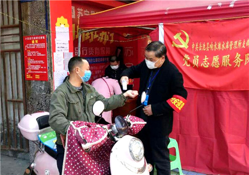 尹国华（右一）细心为出入人员测量体温.jpg