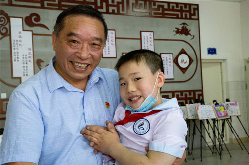 ２．刘树军与他帮助的一名贫困残疾儿童在一起。.jpg